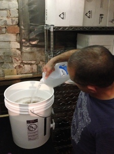 Tim tops up fermenter to 6 gallons.